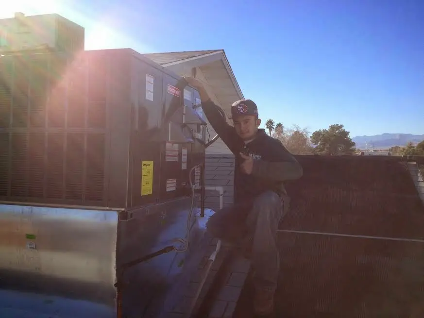 HVAC technician performing Air Duct Cleaning on a rooftop unit in Pasadena Hills